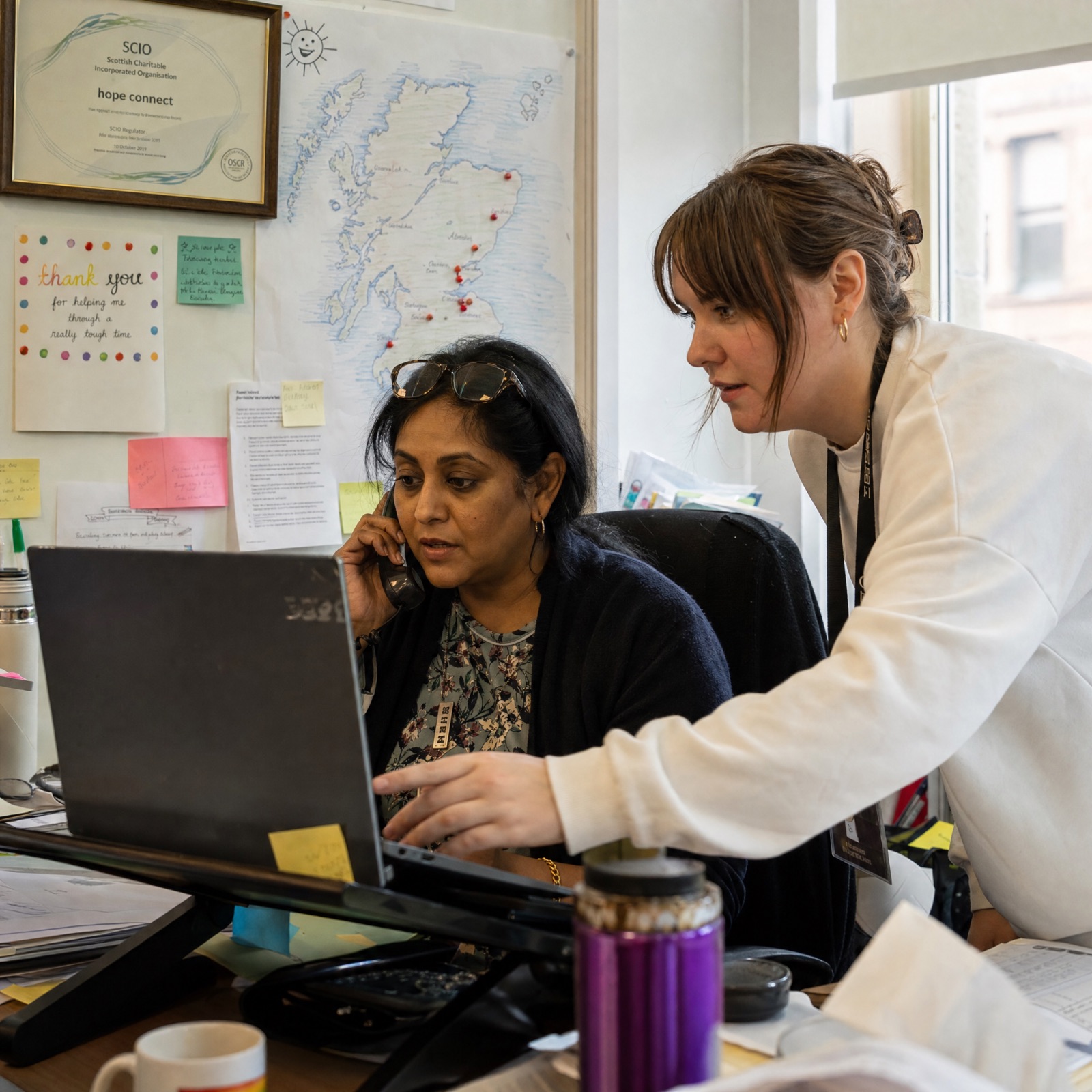 A health advocate and a worker share a quiet, supportive conversation in a site welfare room
